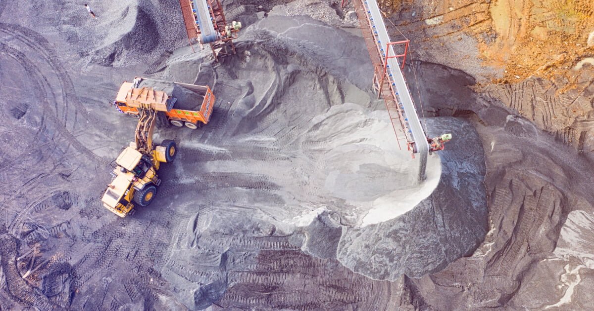 A imagem destaque do post Automação SAP trará economia de R$2 milhões à Samarco é um campo aberto com máquinas escavadeiras trabalhando. Elas são amarelas e contrastam com a imensidão do cinza da mina onde estão desempenhando suas atividades.